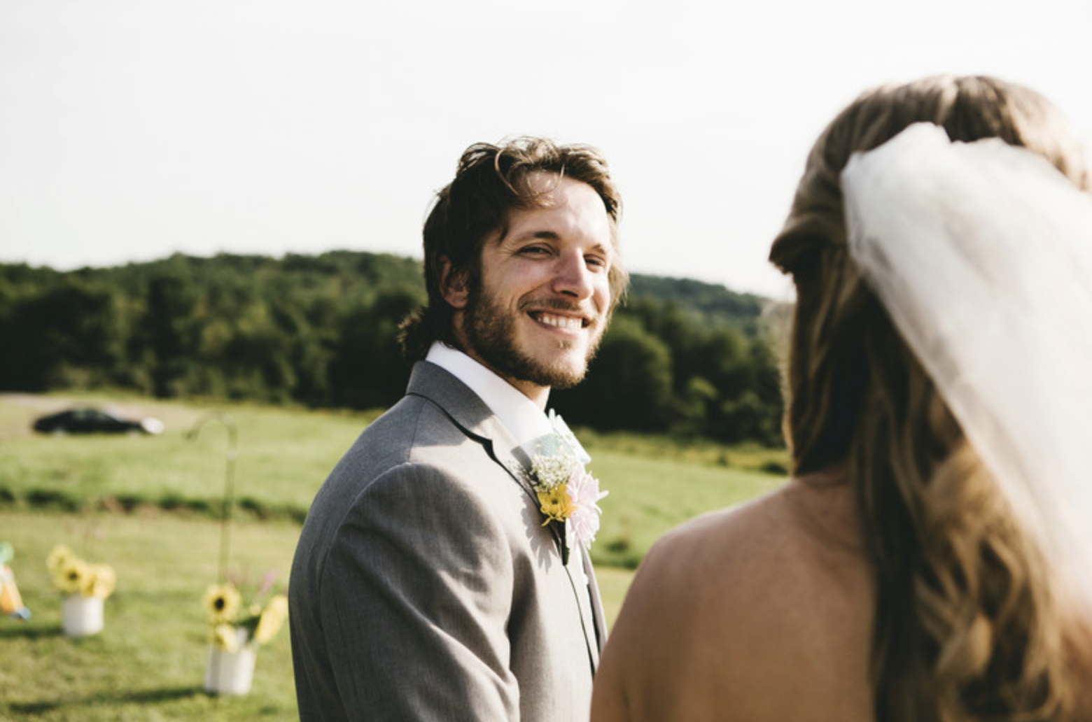Happy groom in gray tuxedo outdoors